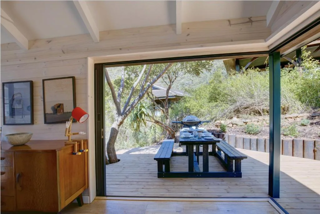 Wooden deck with picnic table overlooking garden trees and natural landscape