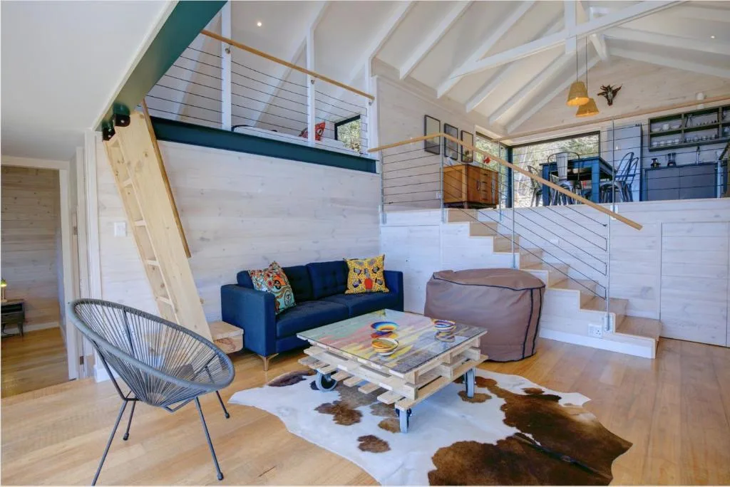 Modern lounge with navy sofa, patterned cushions, and open-plan layout