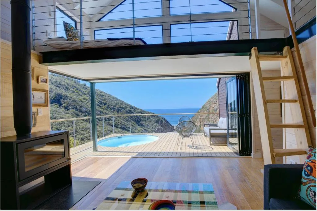 Ocean and mountain vista framed through modern villa's glass doors
