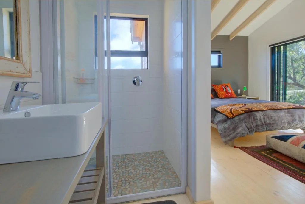 Modern bathroom with vessel sink, shower enclosure, and natural light