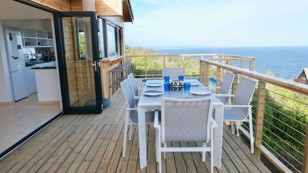 Outdoor dining table with ocean view from wooden deck