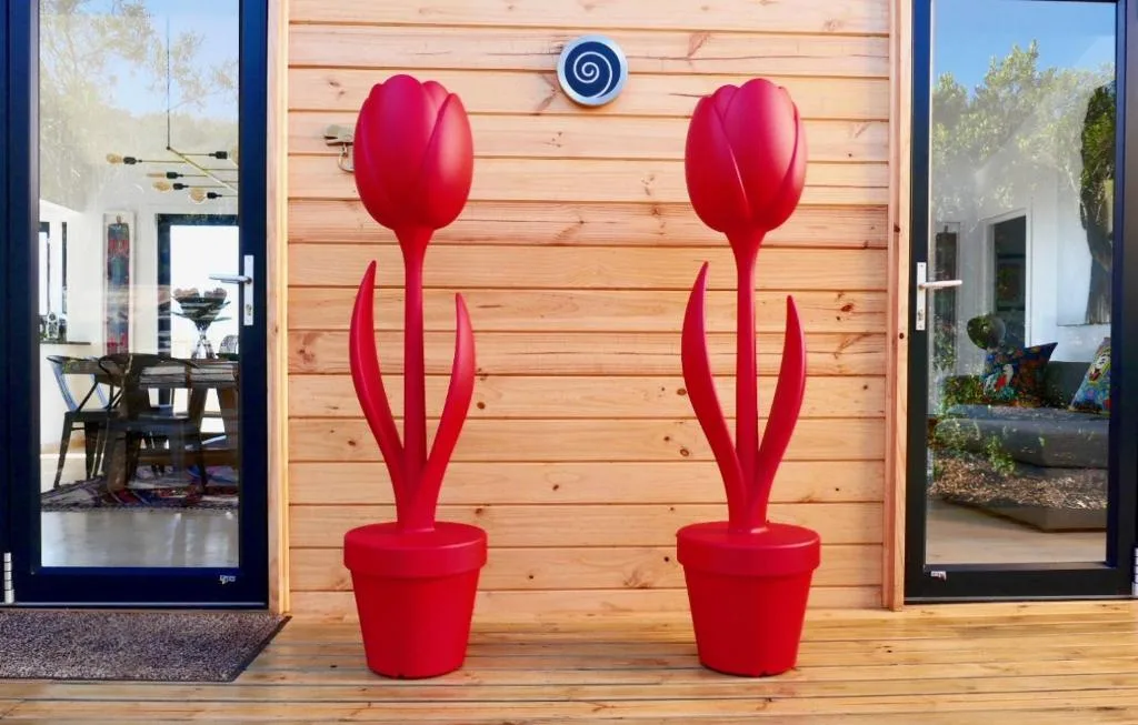 Modern villa entrance with red tulip sculptures and wooden cladding facade