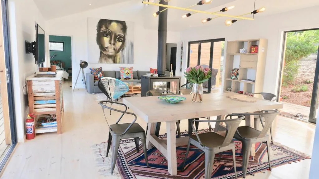 Open-plan living space with dining table, contemporary artwork, and lounge seating