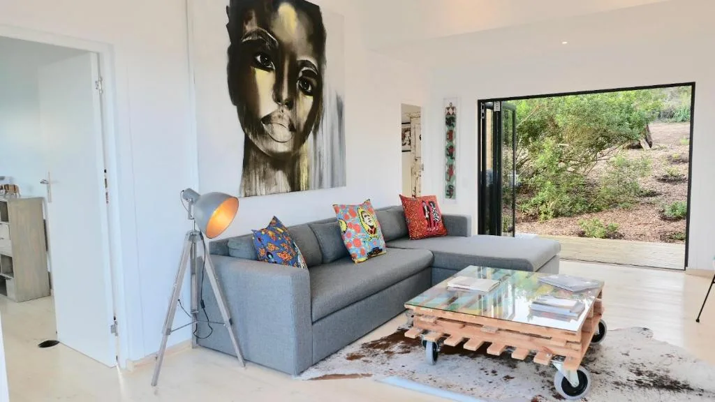 Contemporary lounge with gray sofa, colorful cushions, and garden views