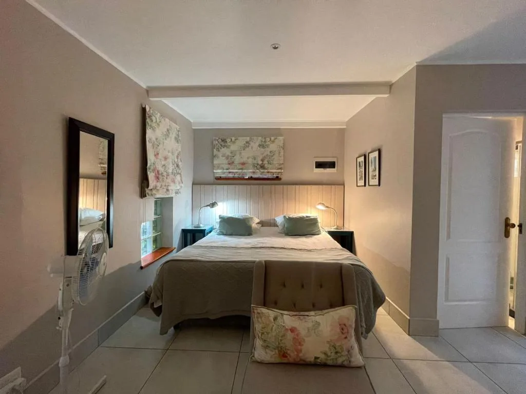 Bright bedroom with double bed, floral pillows, and modern furnishings