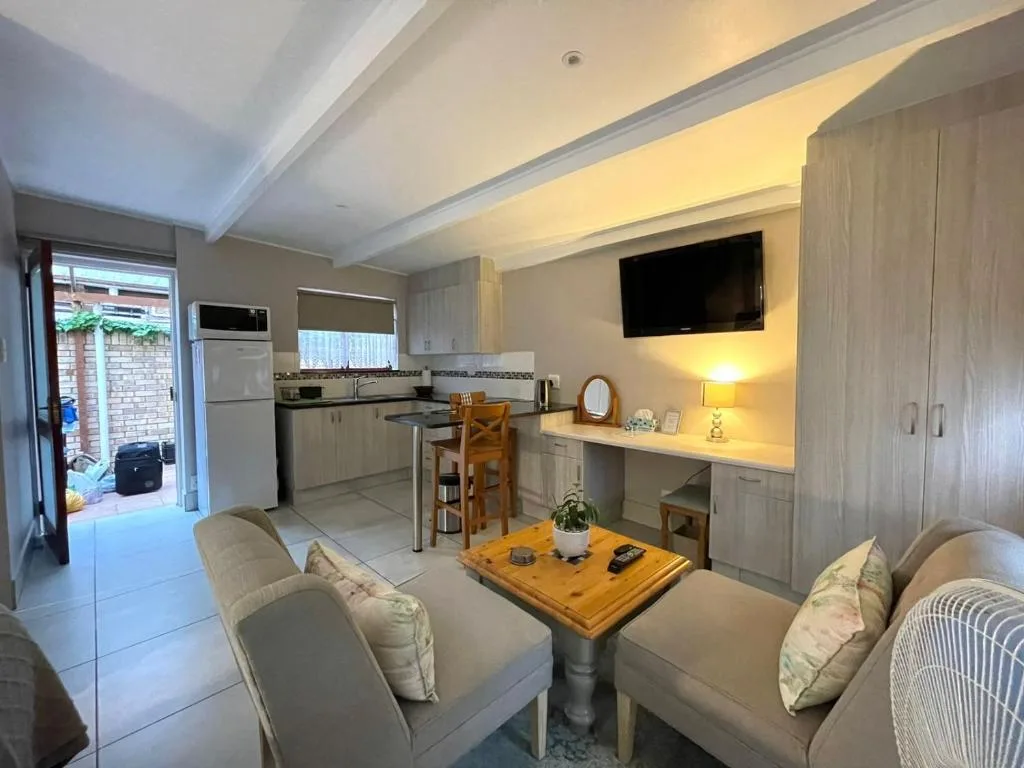 Modern lounge with comfortable seating, wooden table, and wall-mounted television