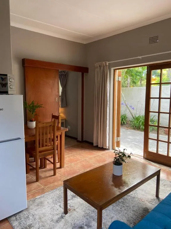 Open-plan lounge with coffee table, sofa, and kitchen access beyond