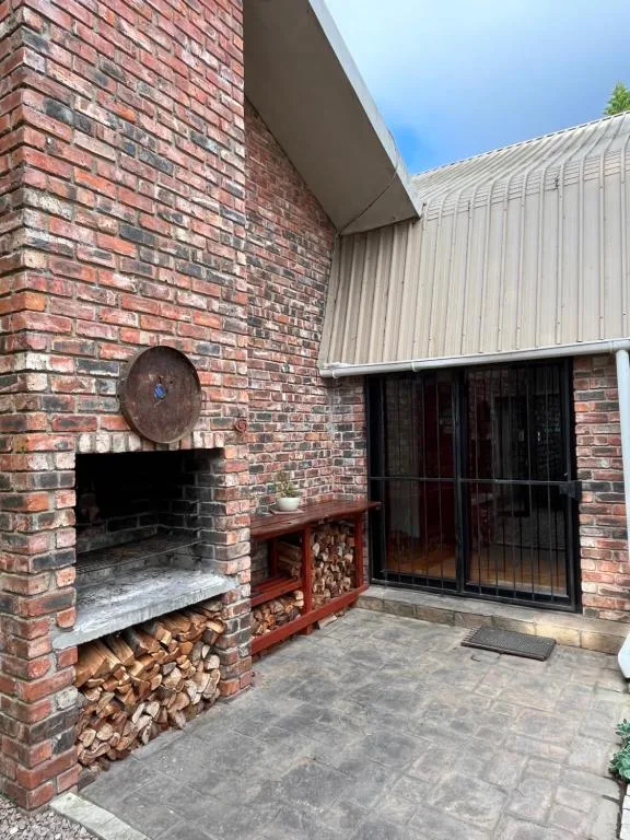 Outdoor patio area with brick fireplace and firewood storage