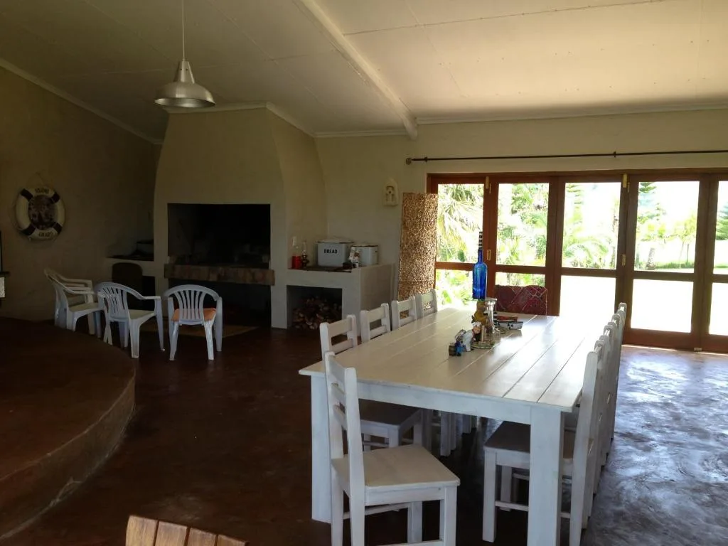 Bright dining room with white table and chairs, garden views through glass doors