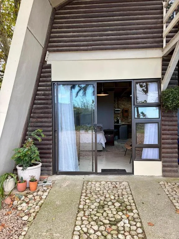 Modern cottage entrance with dark wood cladding and glass sliding doors