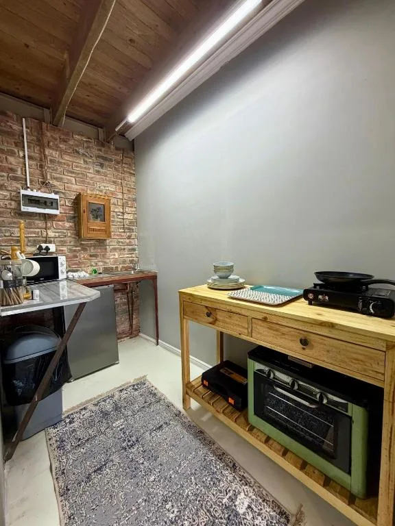 Modern kitchen with brick wall, wooden counters, and built-in appliances