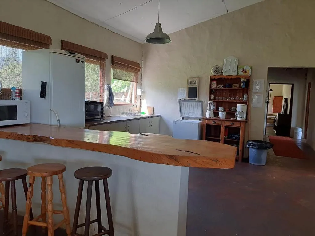 Open-plan kitchen with wooden counter island, refrigerator, and bar seating