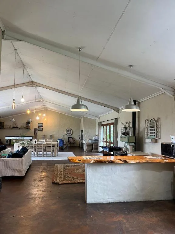 Open-plan lounge with high ceilings, pendant lights, and wooden counter island