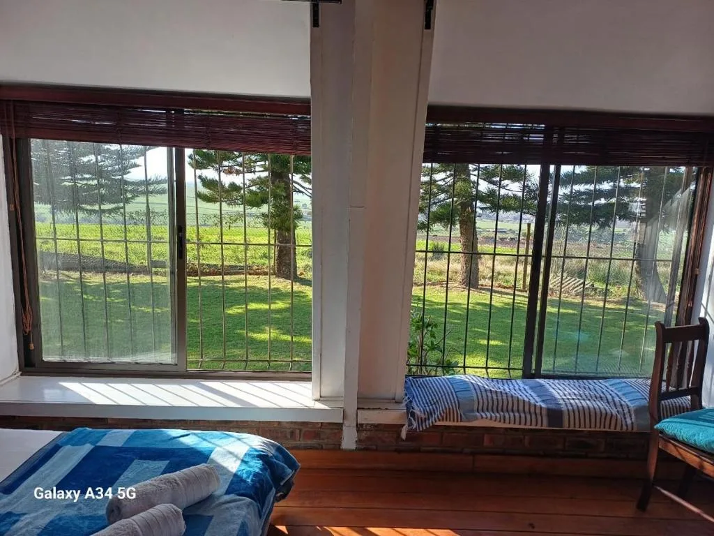 Panoramic green countryside vista through large windows from bedroom