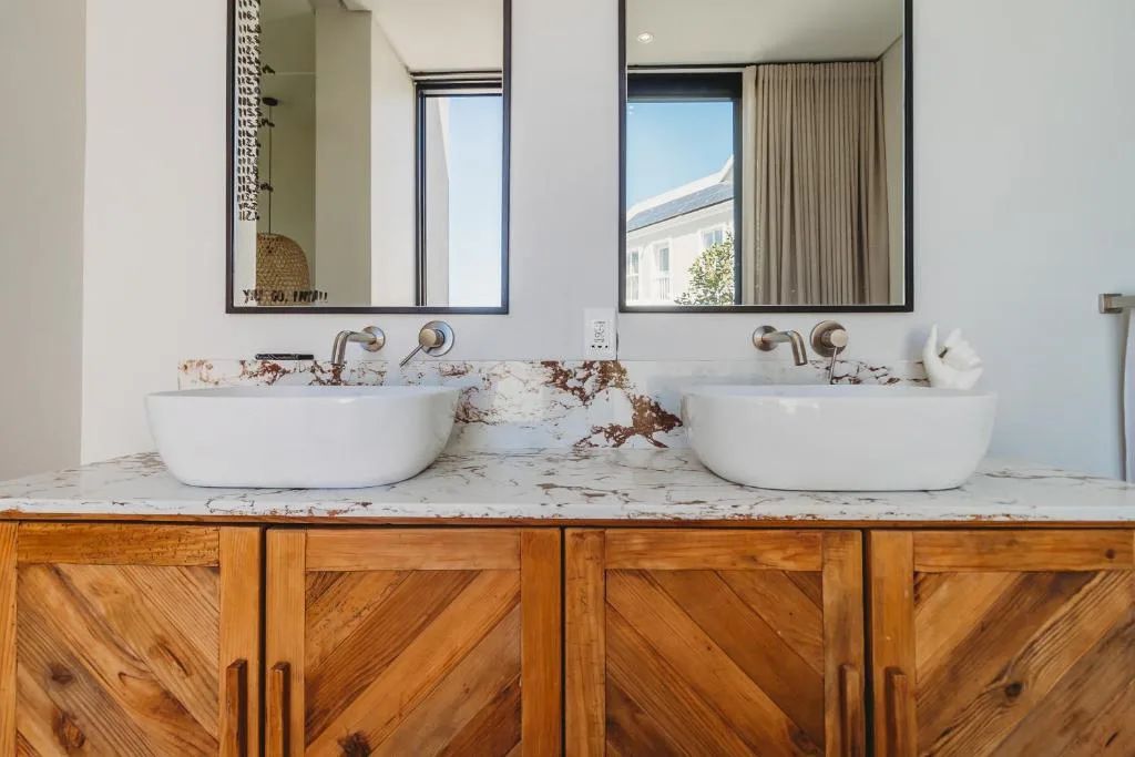 Modern bathroom with dual round white sinks and marble countertop
