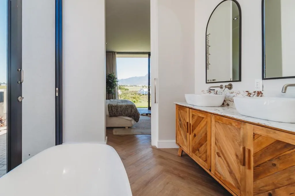 Spacious bathroom with freestanding tub, wooden vanity, and mountain views