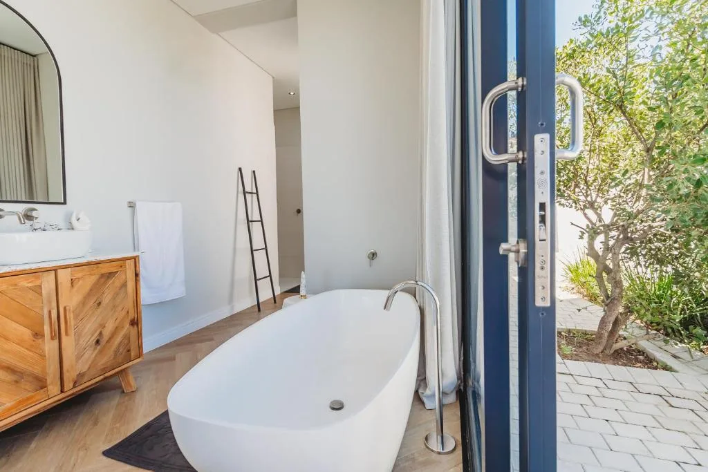 Modern bathroom with freestanding white bathtub and wooden vanity