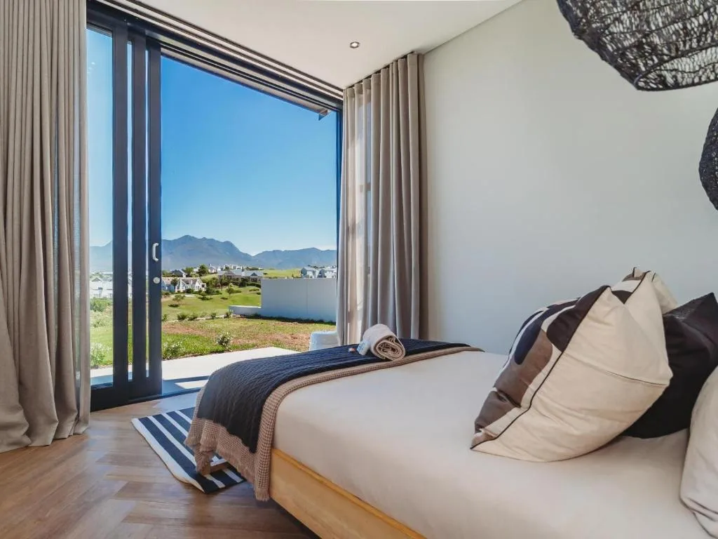 Modern bedroom with mountain and valley views through sliding glass doors