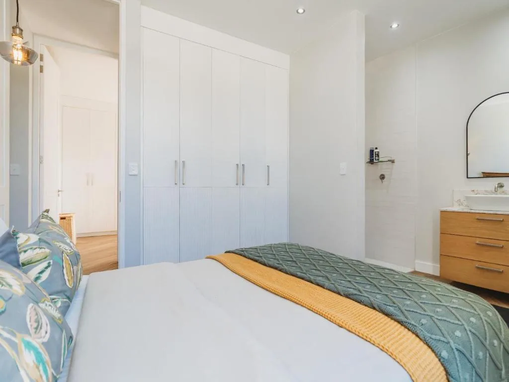 Bright modern bedroom with bed, built-in wardrobes, and ensuite bathroom