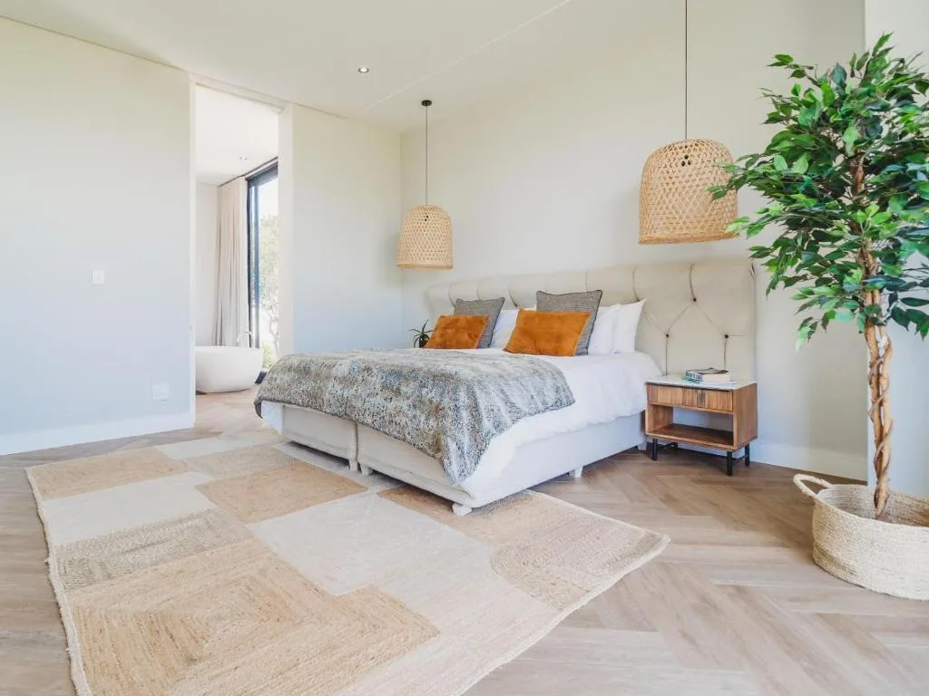 Modern bedroom with bed, woven pendant lights, potted plant, wooden nightstand
