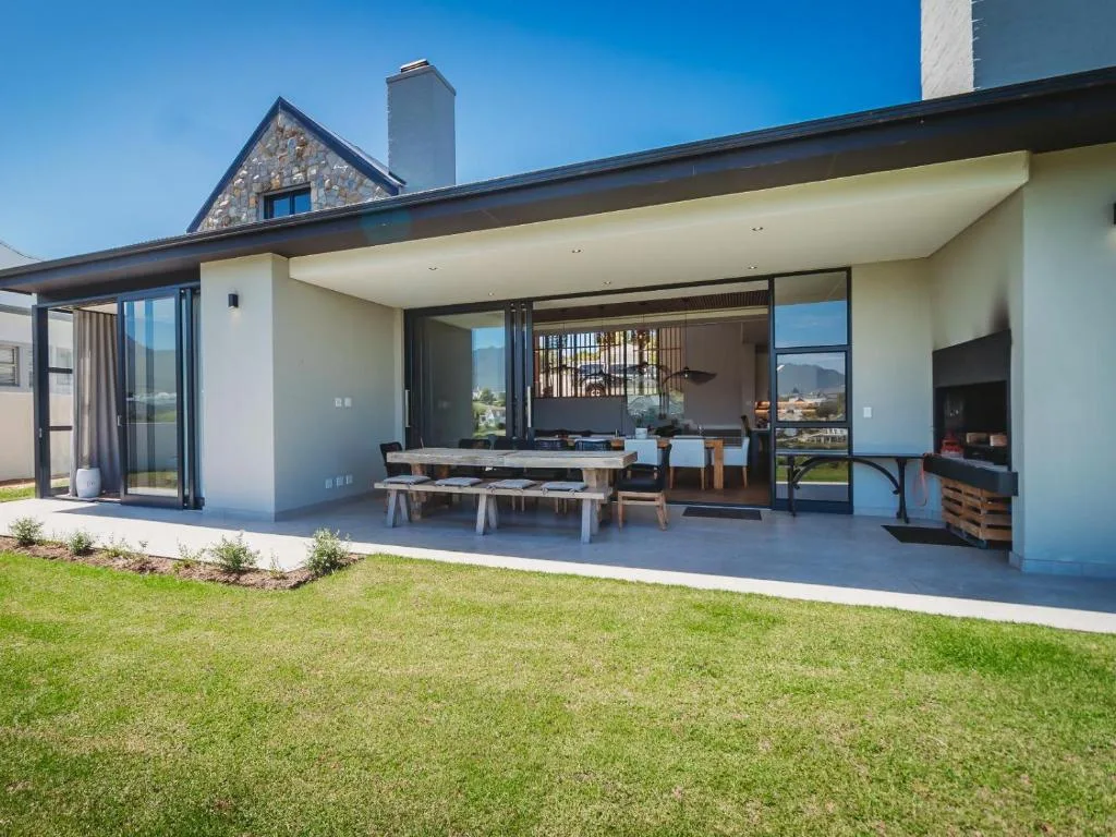 Modern covered patio with dining table, fireplace, and mountain views