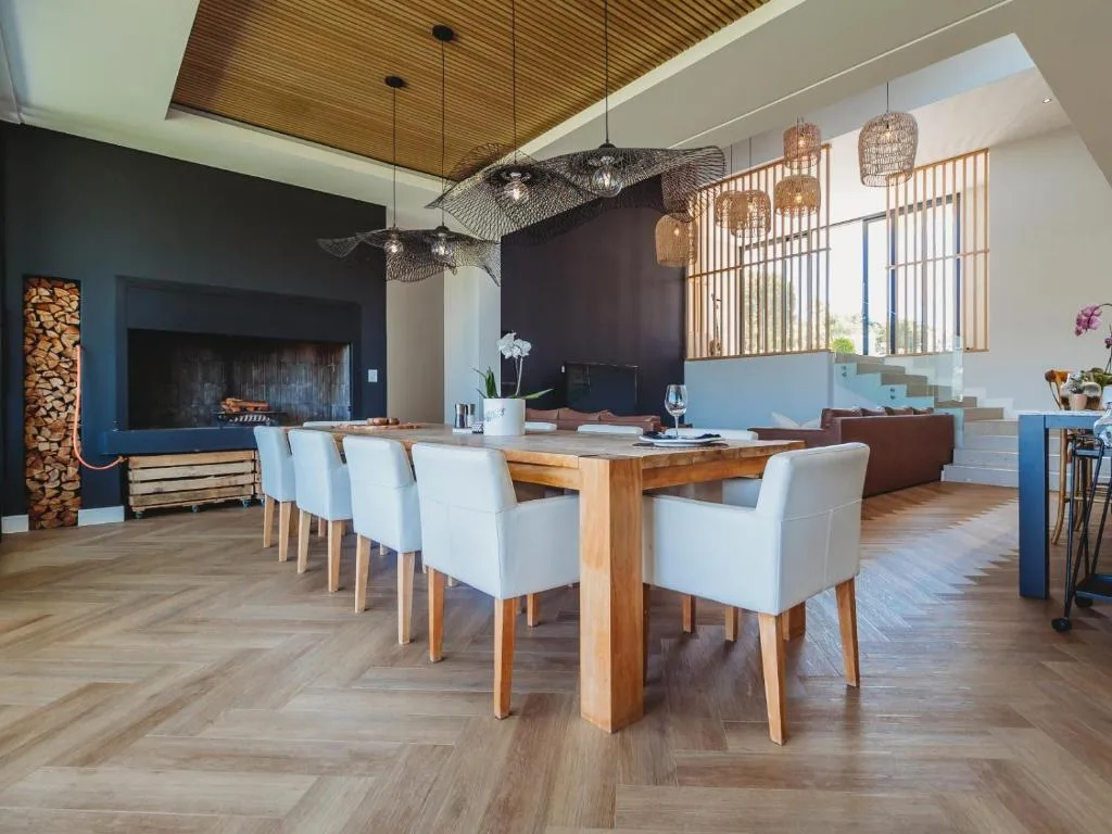 Modern dining area with wooden table and white upholstered chairs