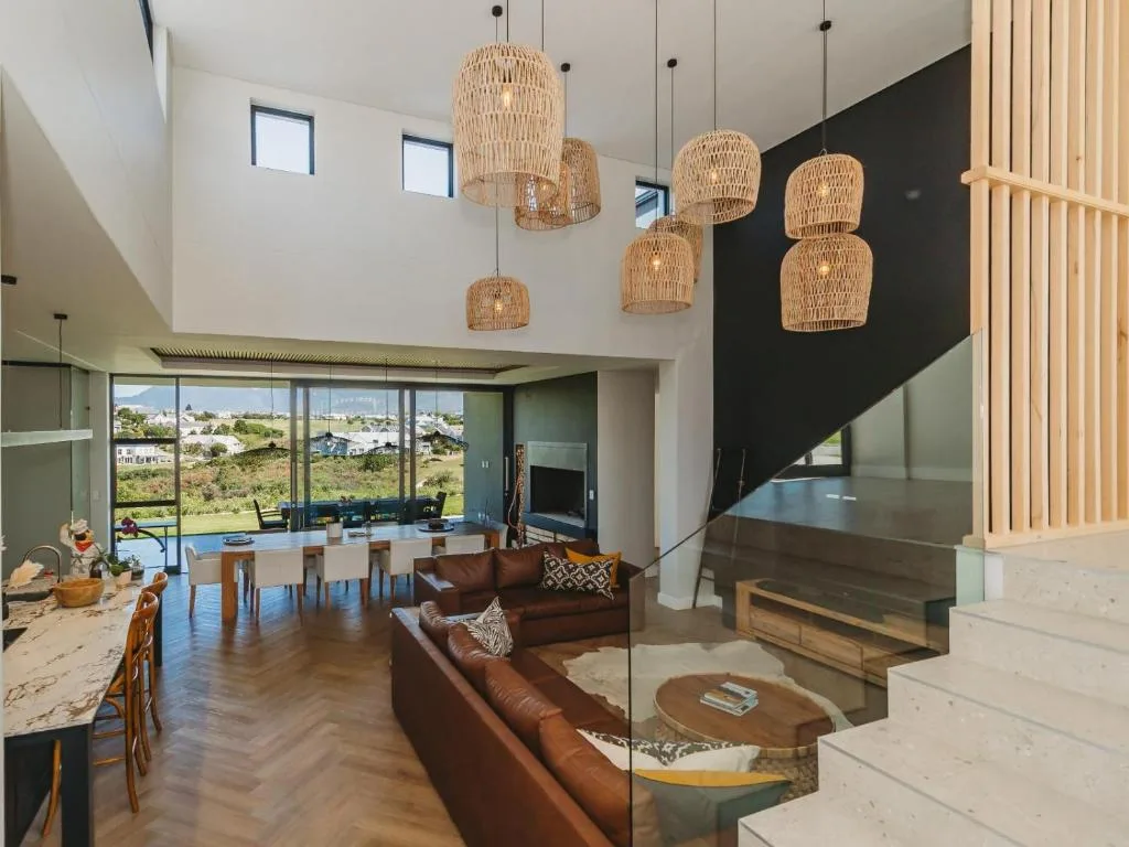 Modern lounge with brown leather sofa and woven pendant lighting fixtures