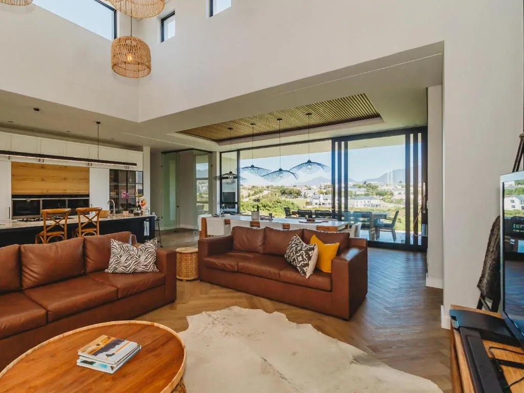 Modern lounge with cognac leather sofas and mountain views through floor-to-ceiling windows