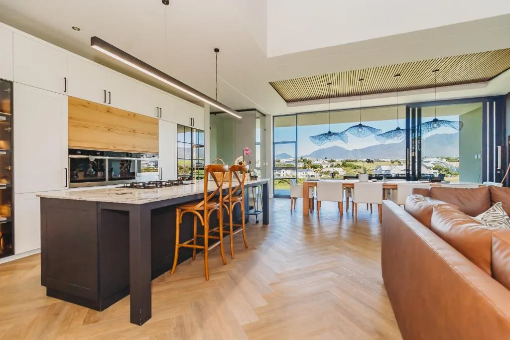 Open-plan lounge with leather sofa and mountain views through large windows