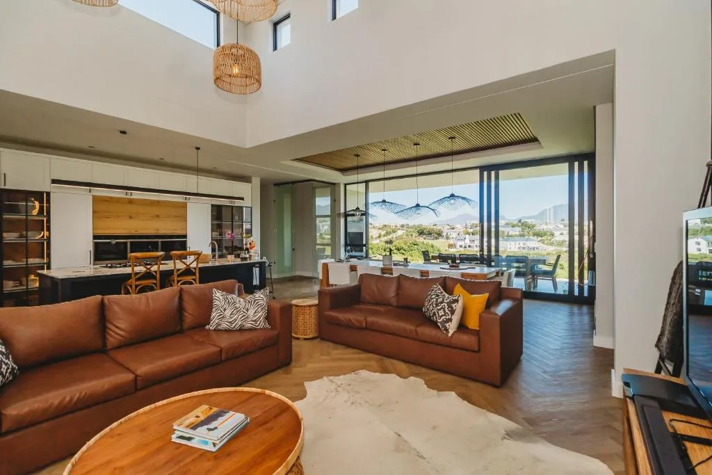 Modern lounge with cognac leather sofas and mountain views through glass doors