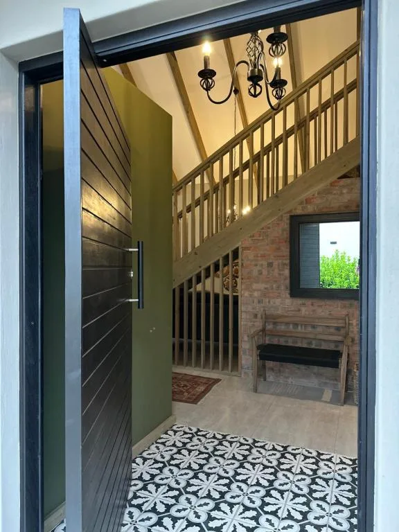 Elegant foyer entrance with patterned tiles and hanging chandelier
