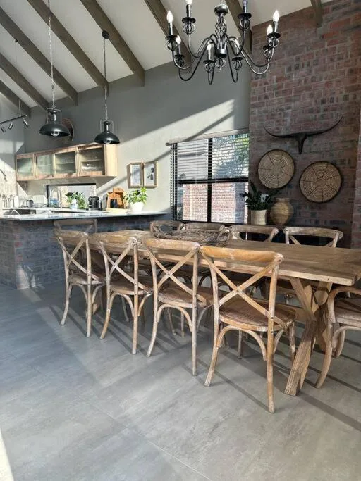Spacious open-plan dining area with wooden table and cross-back chairs