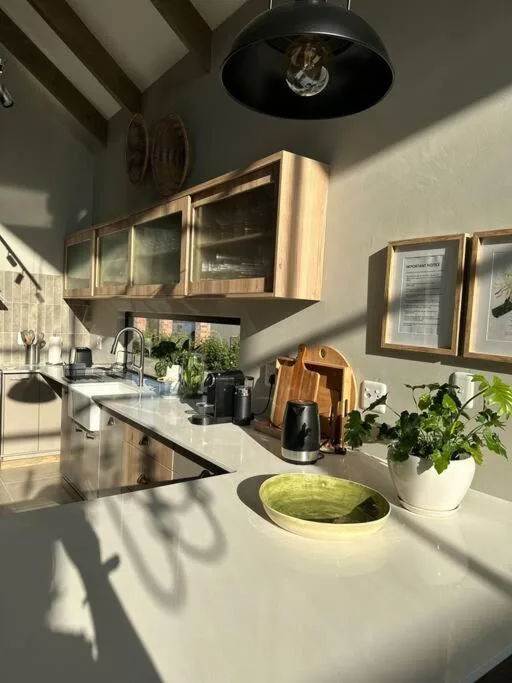 Modern kitchen with stainless steel appliances, white countertops, and suspended cabinetry