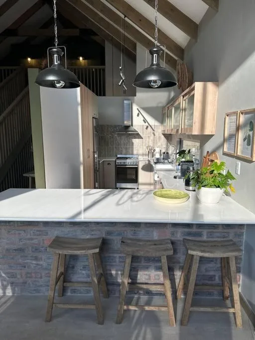 Modern kitchen with island bench, pendant lights, and stainless steel appliances