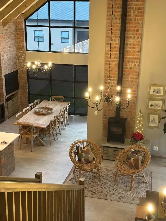 Open-plan lounge with wicker chairs, fireplace, and dining area beyond