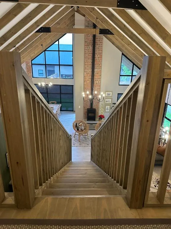 Open-plan lounge with vaulted wooden beams and brick fireplace visible below