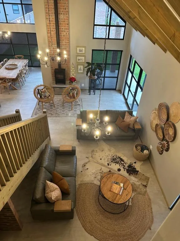 Open-plan lounge with sofa, wooden furniture, and industrial brick fireplace