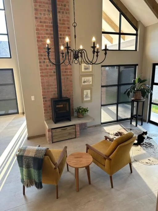 Modern lounge with yellow chairs, fireplace, and pendant lighting