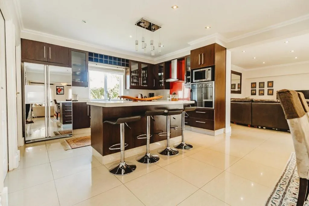Modern kitchen with dark cabinetry, island seating, and stainless steel appliances