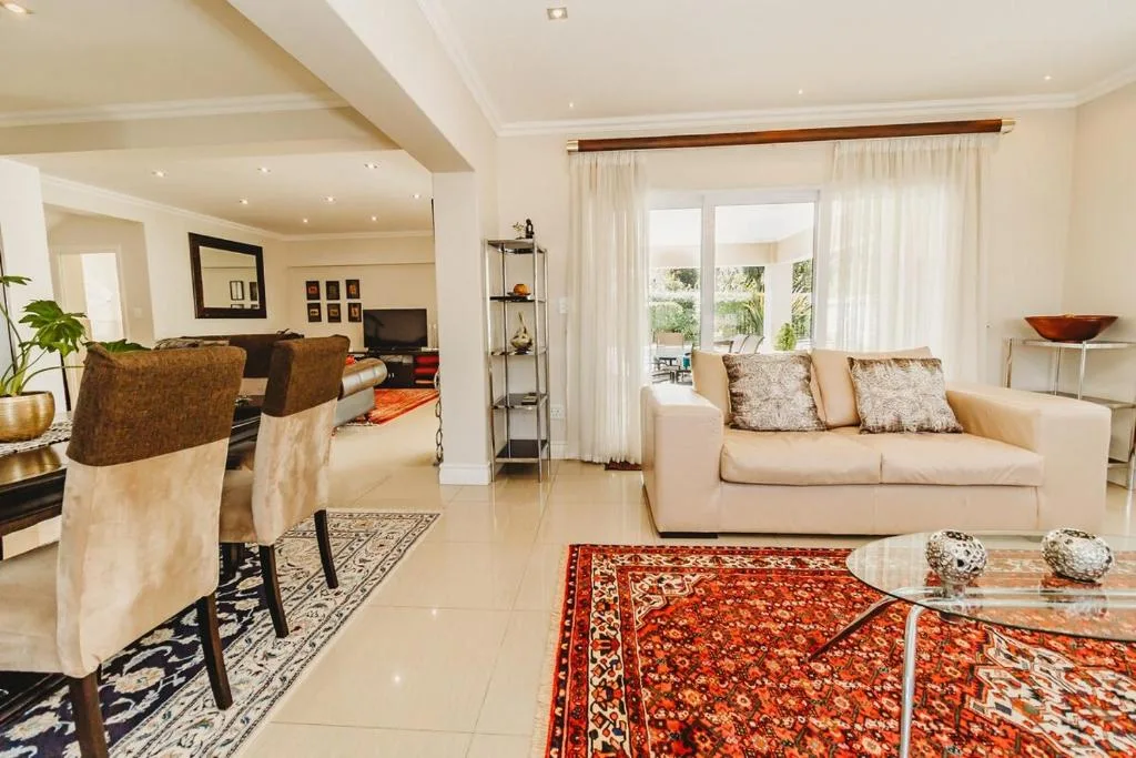 Spacious lounge with cream sofa, decorative rugs, and garden views