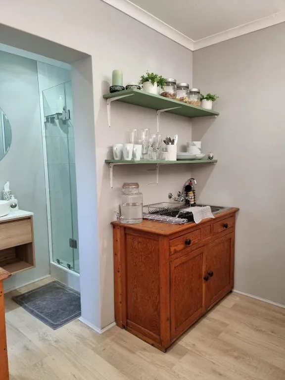 Bathroom vanity with wooden cabinet and open shelving displaying toiletries