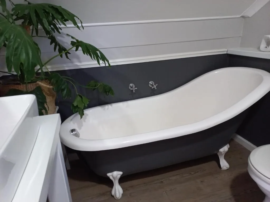 Luxurious black and white freestanding bathtub with chrome fixtures