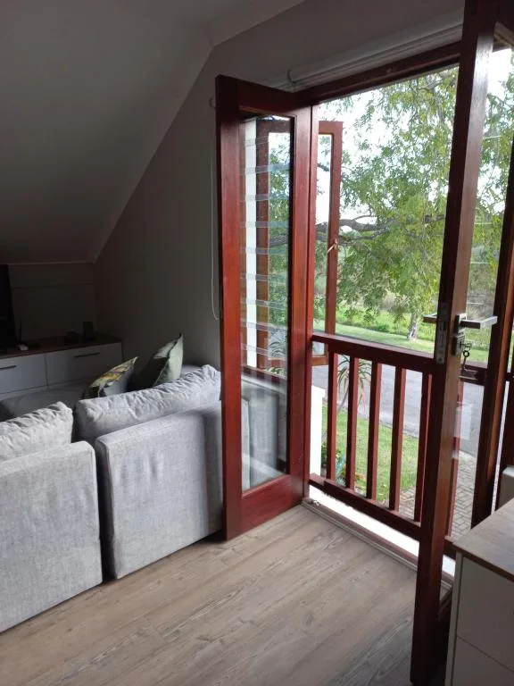 Cozy bedroom with bed and glass doors opening to garden views