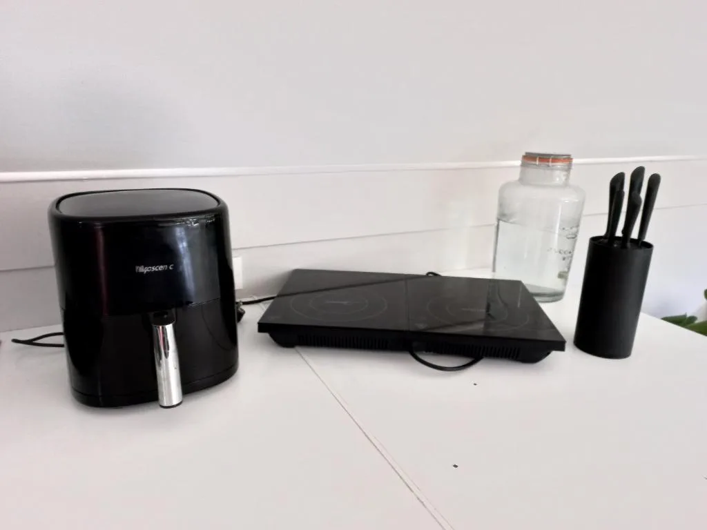 Kitchen countertop with air fryer, cooling tray, and knife block