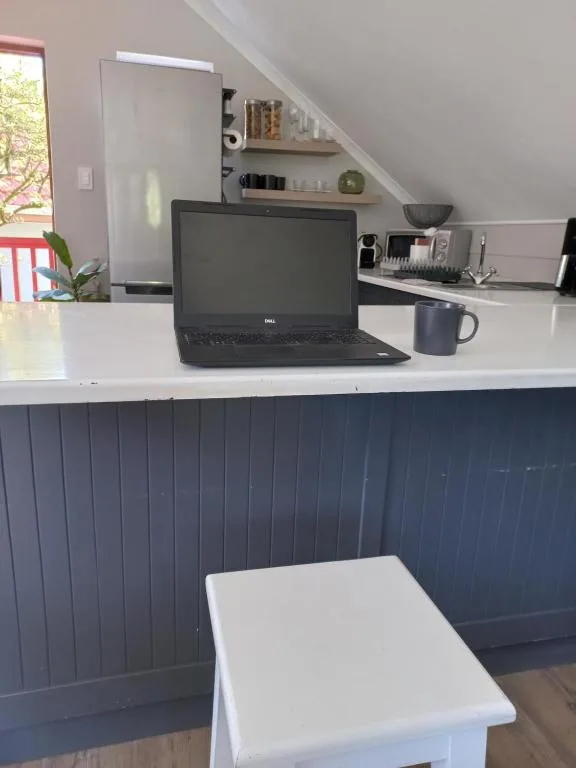 Modern workspace with laptop, coffee mug, and organized shelving in bright room