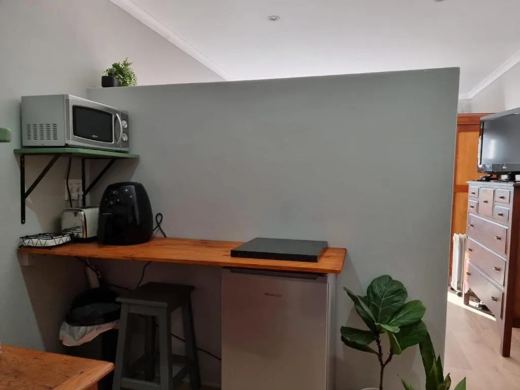 Modern kitchenette with microwave, workspace desk, and storage cabinetry