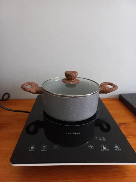 Modern induction cooktop with gray speckled pot and wooden handles