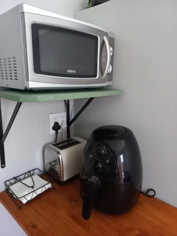 Microwave, toaster, and air fryer on wooden kitchen counter