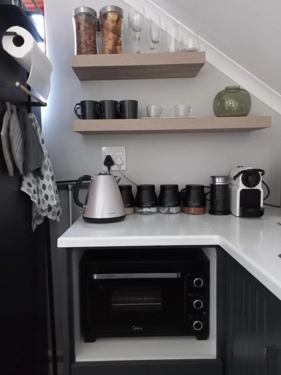 Modern kitchen corner with electric oven, kettle, and organized shelving