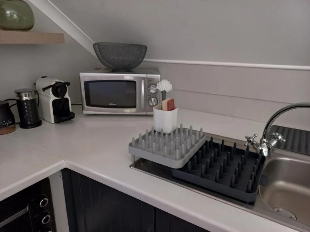 Modern kitchen counter with microwave, coffee machine, and dish rack